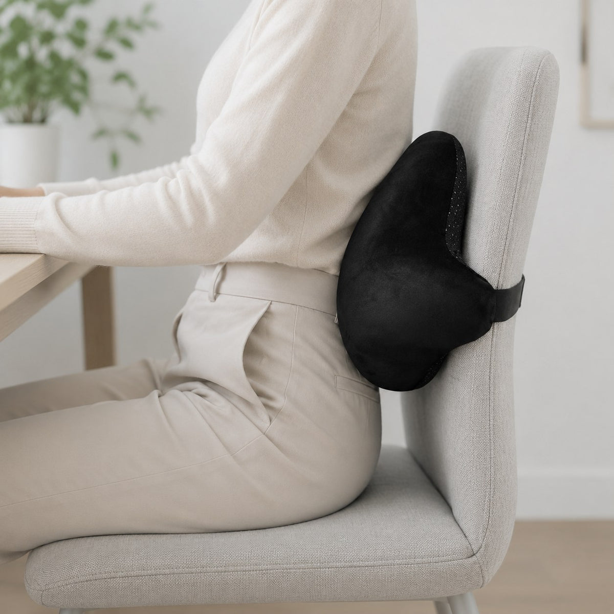ダイニングチェアの背もたれと腰のあいだに整体エルゴバッククッションを当てて座っているところ